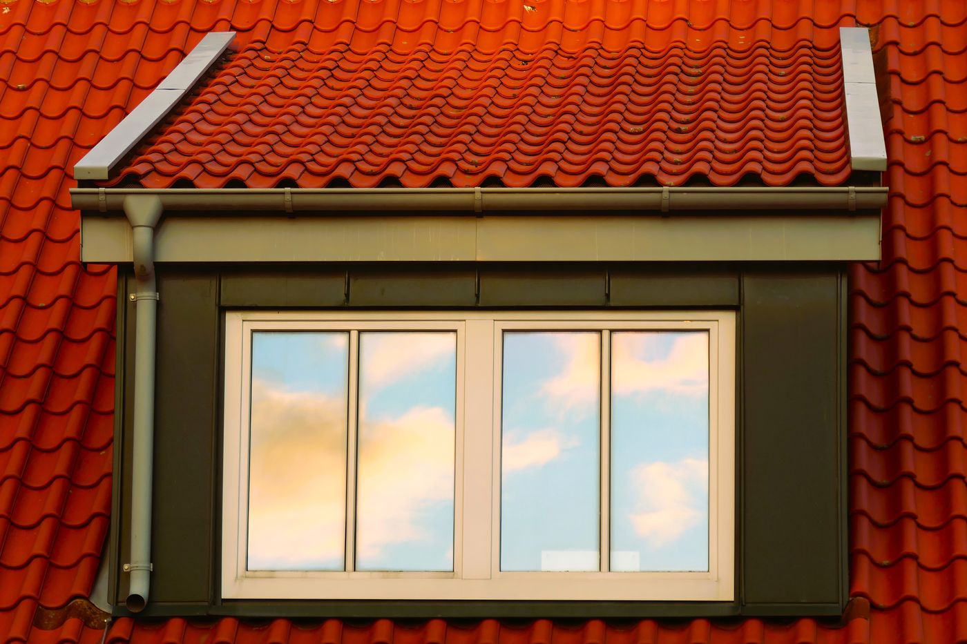 Stock photograph of a terracotta tiled roof with a dormer window